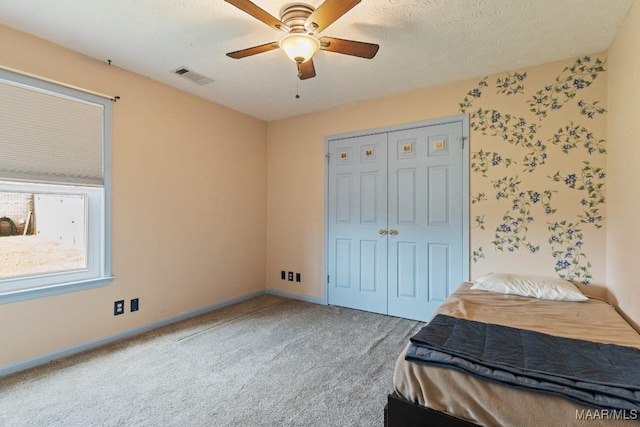 carpeted bedroom featuring a closet, baseboards, and ceiling fan