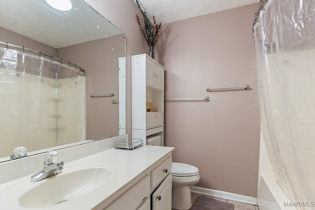 bathroom with a textured ceiling, toilet, vanity, baseboards, and tile patterned flooring
