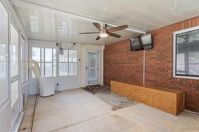 unfurnished sunroom featuring a ceiling fan
