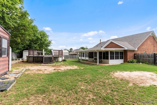 view of yard with a sunroom and a deck