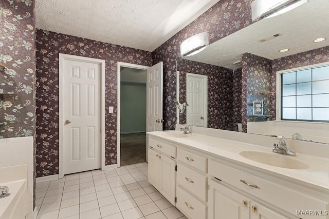 full bathroom with tile patterned flooring, a textured ceiling, a garden tub, baseboards, and wallpapered walls