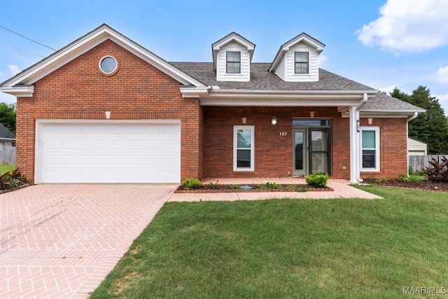 view of front of house featuring brick siding, a front lawn, driveway, roof with shingles, and an attached garage
