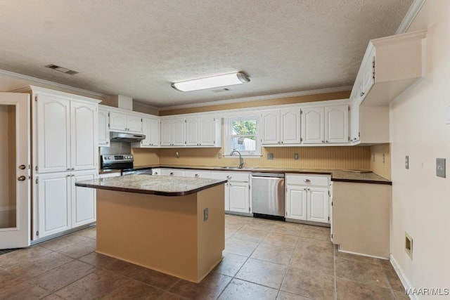 kitchen with appliances with stainless steel finishes, under cabinet range hood, white cabinetry, a kitchen island, and crown molding
