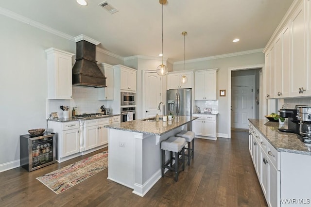 184 Houston St, Prattville, AL 36066 - kitchen with beverage cooler, stainless steel appliances, visible vents, a sink, and premium range hood