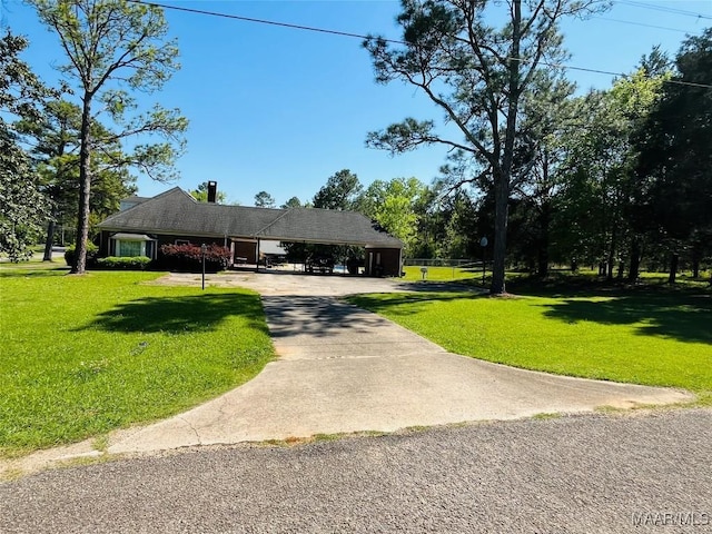 view of front facade featuring a front lawn, driveway, and an attached carport