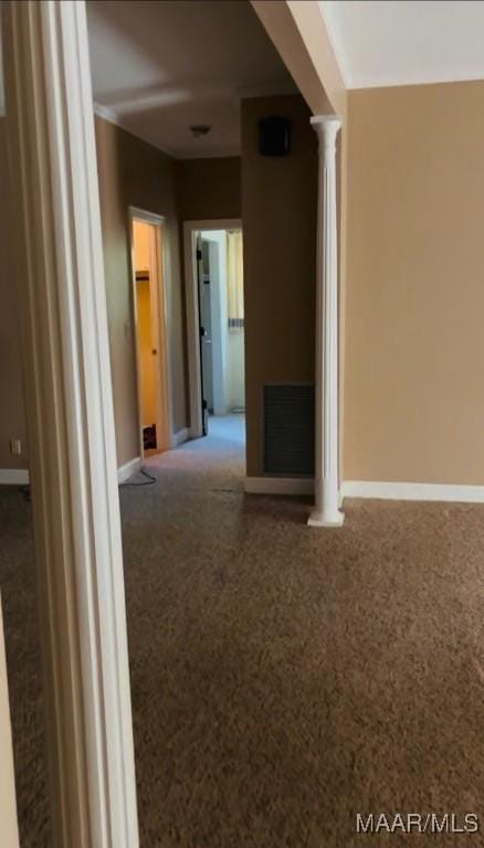 interior space with baseboards, visible vents, and ornate columns