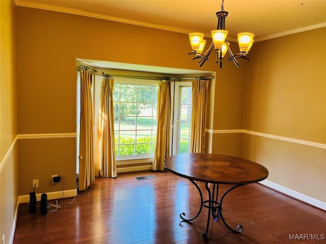 unfurnished dining area featuring crown molding, wood finished floors, baseboards, a notable chandelier, and visible vents