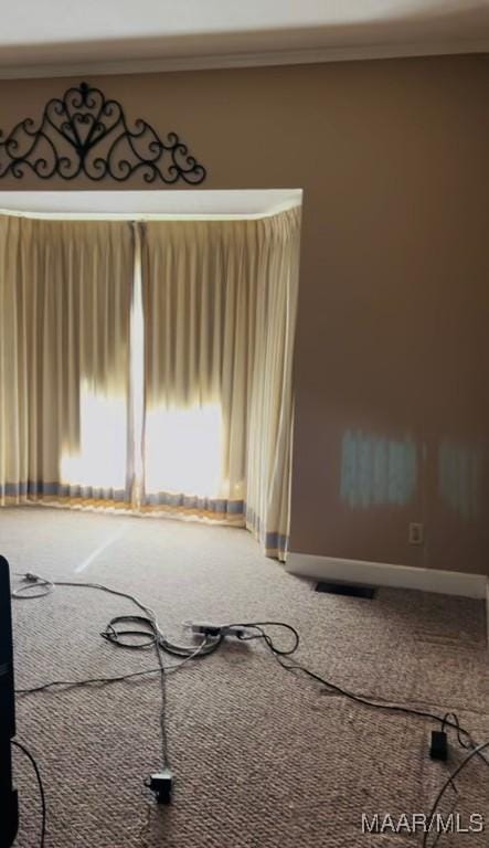 carpeted empty room featuring visible vents and baseboards