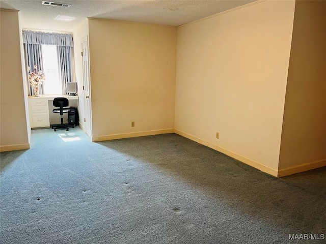 carpeted spare room with a textured ceiling, baseboards, and visible vents