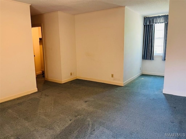 spare room with baseboards, carpet, and a textured ceiling