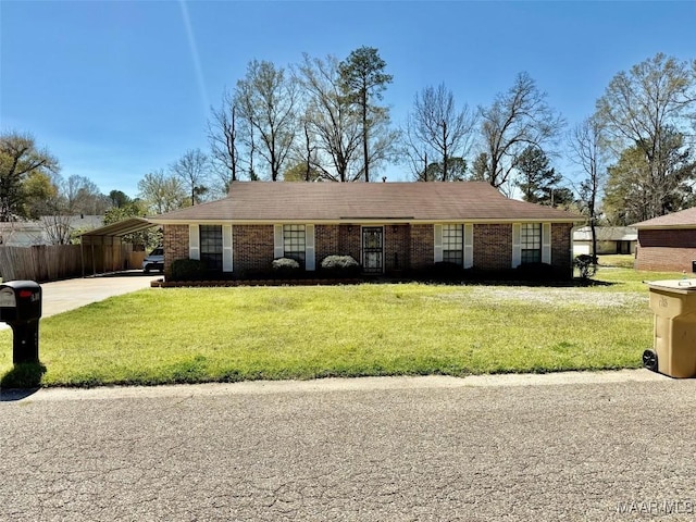 ranch-style home featuring a front lawn, driveway, a carport, and fence