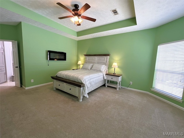 bedroom featuring carpet floors, a textured ceiling, visible vents, and baseboards