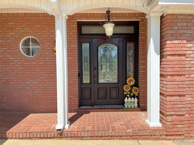 property entrance featuring brick siding and a porch
