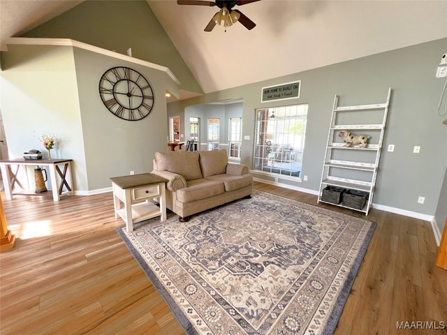 living area featuring baseboards, wood finished floors, high vaulted ceiling, and ceiling fan