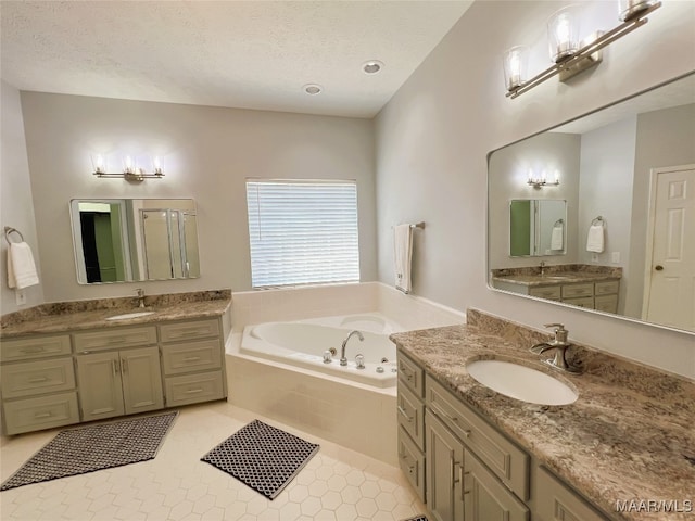 bathroom featuring a garden tub, a sink, a textured ceiling, and a stall shower