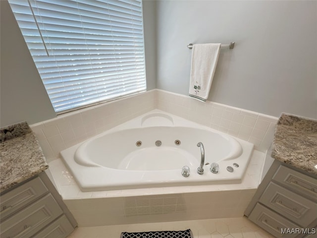 full bath featuring a jetted tub and vanity