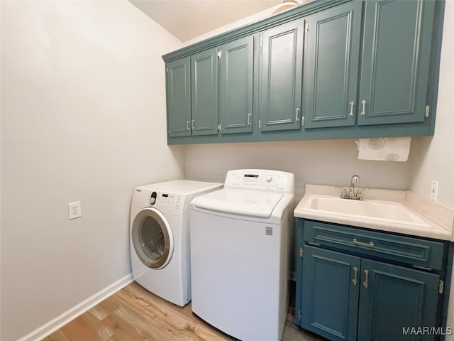 laundry area with a sink, independent washer and dryer, baseboards, cabinet space, and light wood-style flooring
