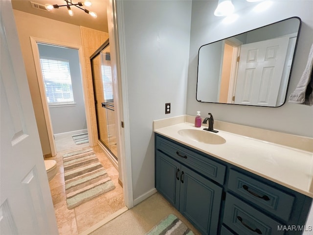 bathroom with a shower stall, toilet, vanity, and visible vents