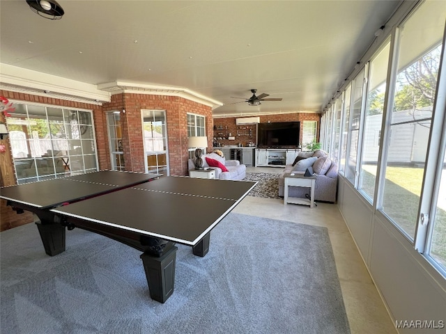 rec room with plenty of natural light, brick wall, and ceiling fan