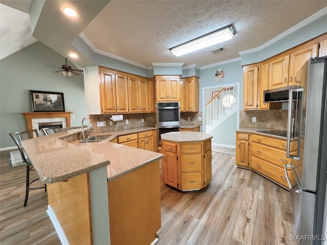 kitchen with stainless steel appliances, a peninsula, a sink, visible vents, and crown molding
