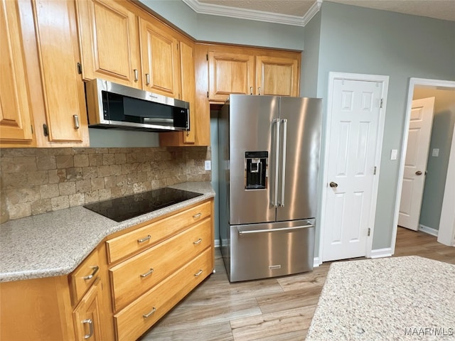 kitchen featuring tasteful backsplash, appliances with stainless steel finishes, light wood-style flooring, baseboards, and ornamental molding