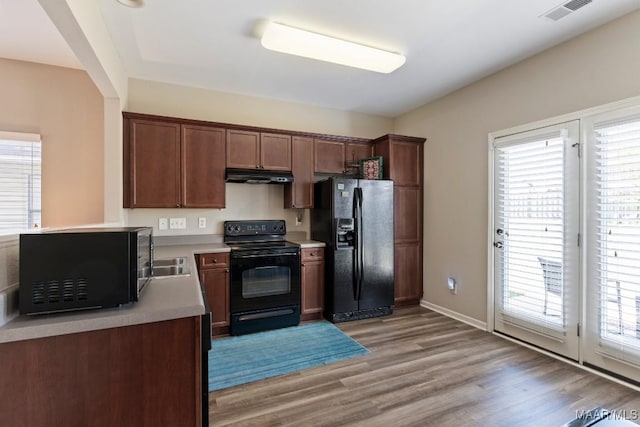 kitchen featuring plenty of natural light, under cabinet range hood, and black appliances