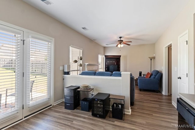 living area featuring wood finished floors, visible vents, ceiling fan, and plenty of natural light