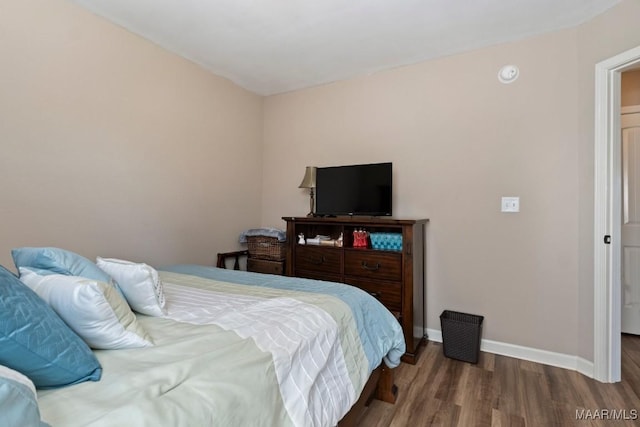 bedroom featuring baseboards and wood finished floors