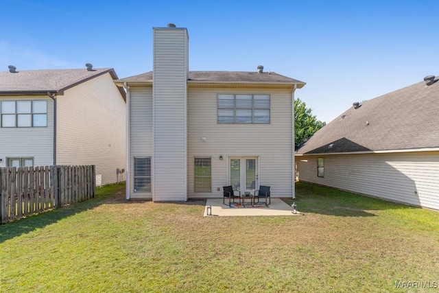 back of property featuring a patio area, a lawn, a chimney, and fence