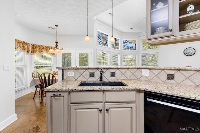 kitchen with a sink, finished concrete floors, dishwasher, backsplash, and baseboards