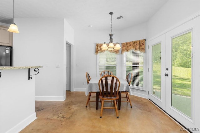 dining room with baseboards, concrete flooring, a notable chandelier, and plenty of natural light