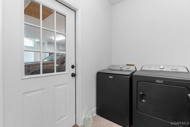 laundry area featuring washing machine and clothes dryer, baseboards, and laundry area