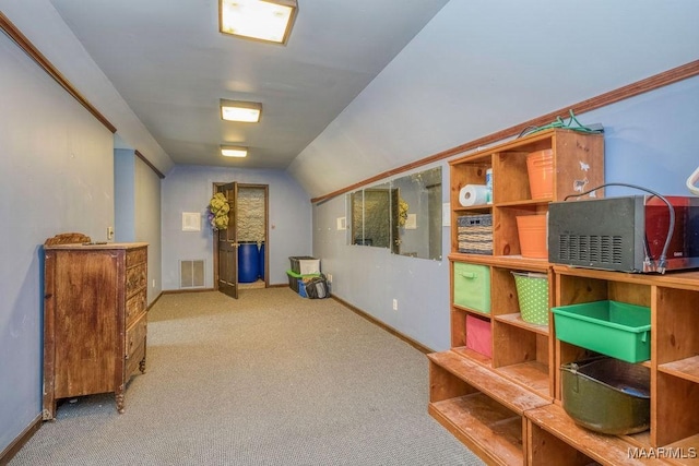 hallway featuring baseboards, carpet, and lofted ceiling