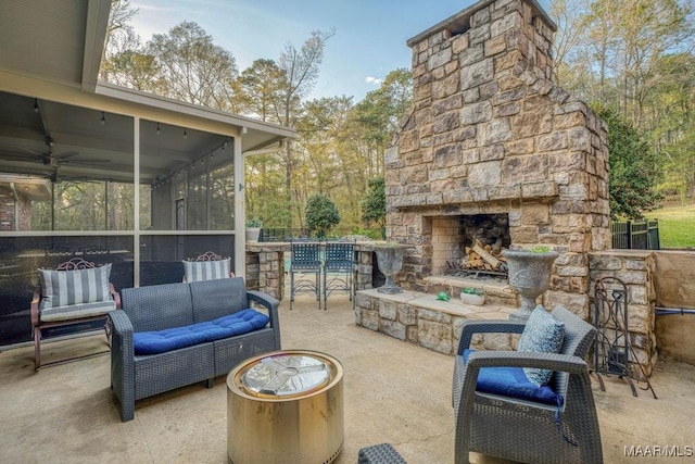 view of patio featuring an outdoor living space with a fireplace and a sunroom