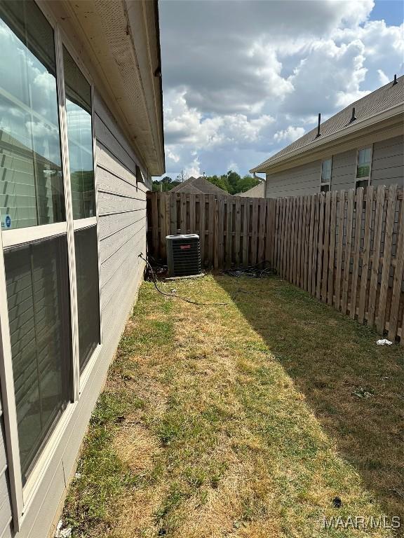 view of yard featuring fence and cooling unit