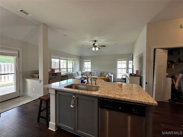 kitchen featuring light stone countertops, stainless steel dishwasher, ceiling fan, a sink, and visible vents