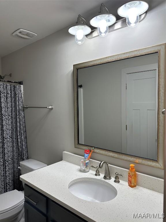 full bathroom featuring toilet, visible vents, vanity, and a shower with shower curtain