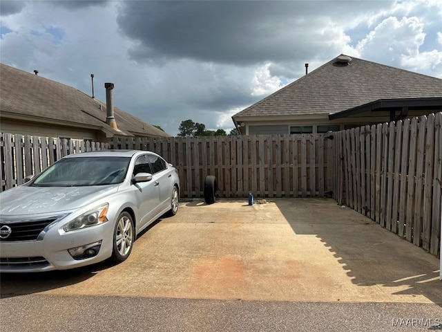 view of vehicle parking with fence