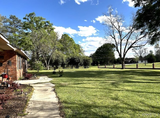view of home's community with a lawn and fence