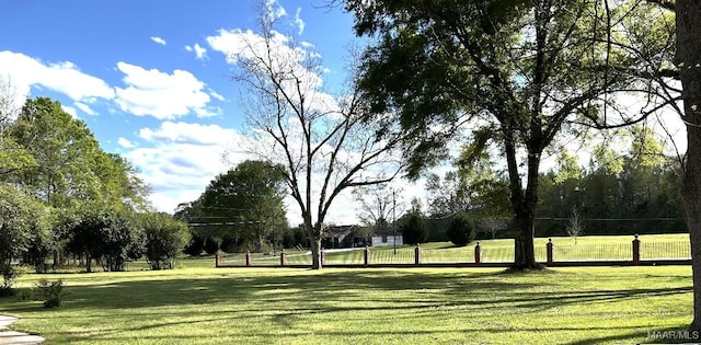 view of property's community with a lawn and fence