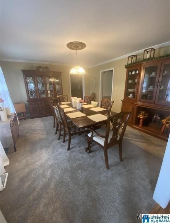 carpeted dining area with crown molding