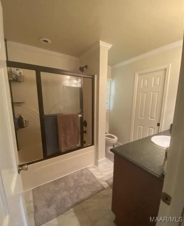 bathroom with tile patterned floors, toilet, vanity, crown molding, and bath / shower combo with glass door