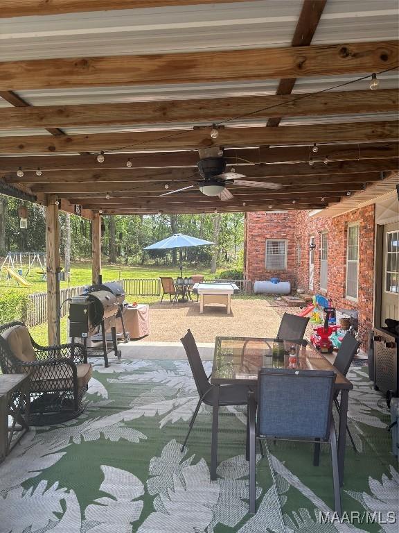 view of patio featuring fence, outdoor dining space, and ceiling fan