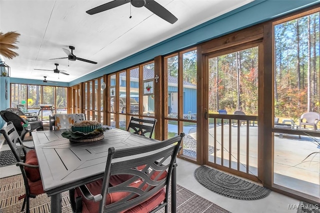sunroom with a ceiling fan and outdoor dining area