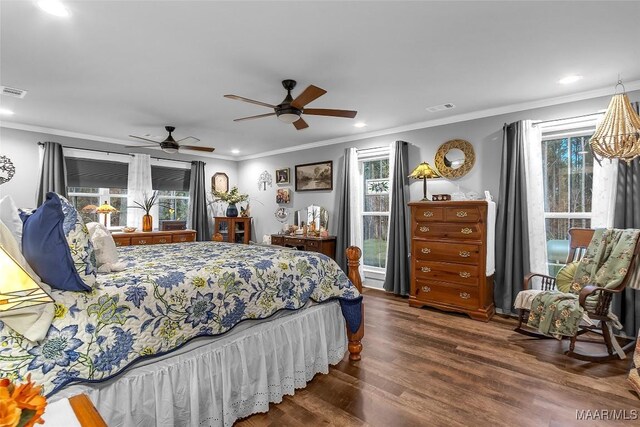 bedroom featuring wood finished floors, visible vents, crown molding, and multiple windows