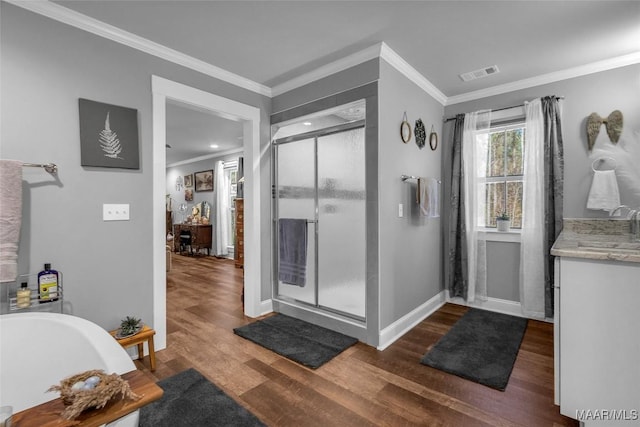 full bathroom featuring visible vents, a freestanding tub, wood finished floors, a shower stall, and crown molding