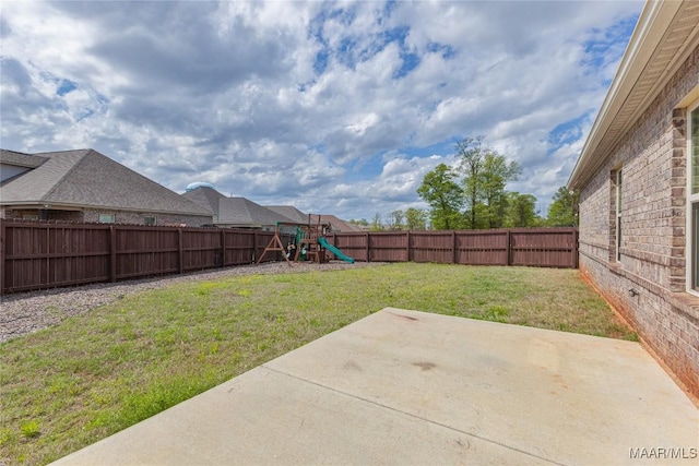 view of yard featuring a patio area, a fenced backyard, and a playground