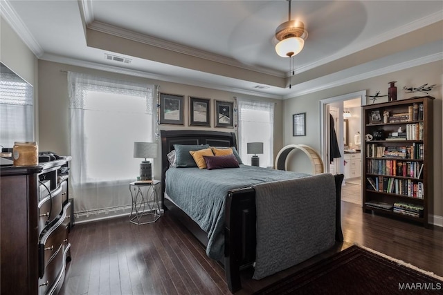 bedroom featuring dark wood finished floors, ornamental molding, visible vents, and a raised ceiling
