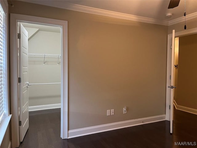 unfurnished bedroom featuring baseboards, dark wood-style floors, a closet, and ornamental molding