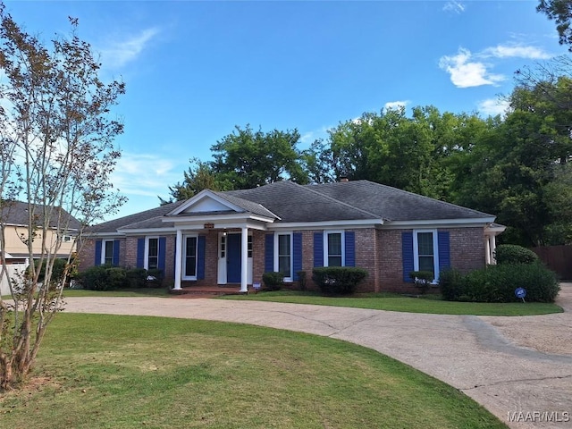 view of front facade featuring brick siding, a front yard, a porch, and a shingled roof